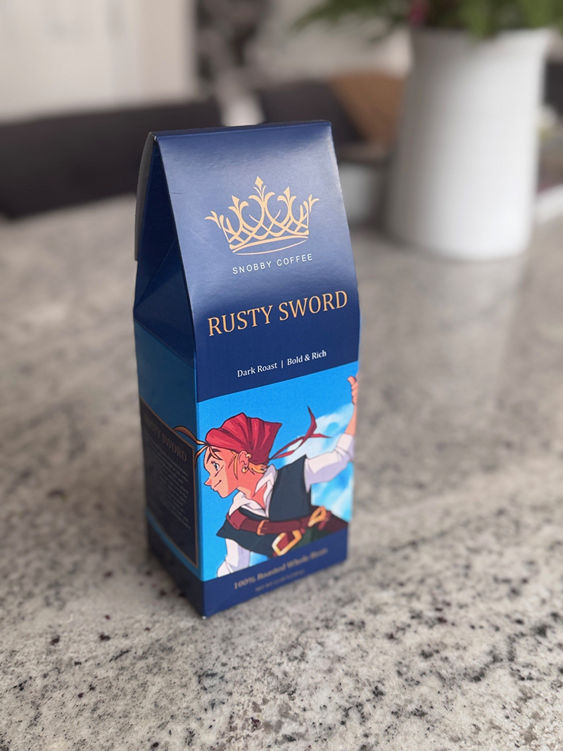 Blue coffee packaging with 'Rusty Sword' branding on a marble surface.